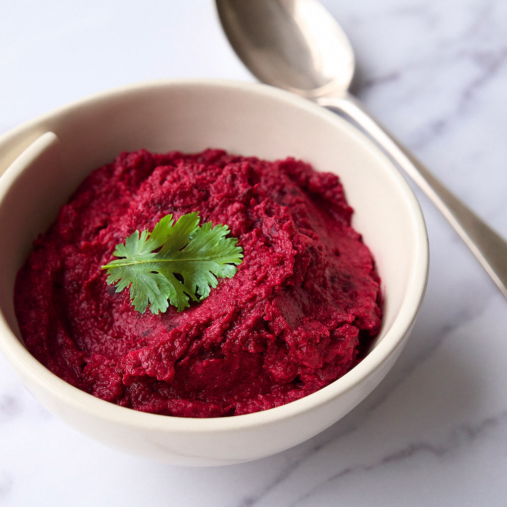 Bowl of houmous made with beetroot and haskapa